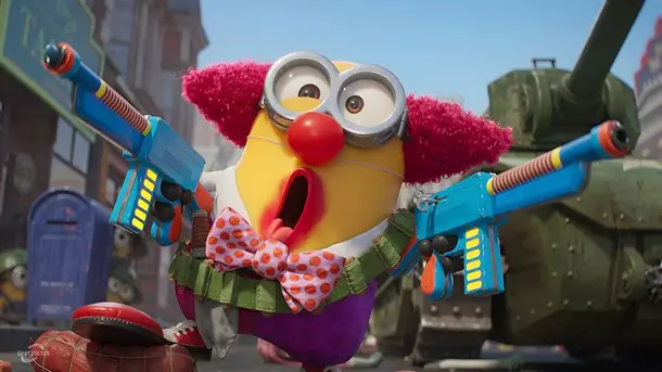 Bohócnak öltözött sárga minion két kék játékfegyverrel egy tank előtt